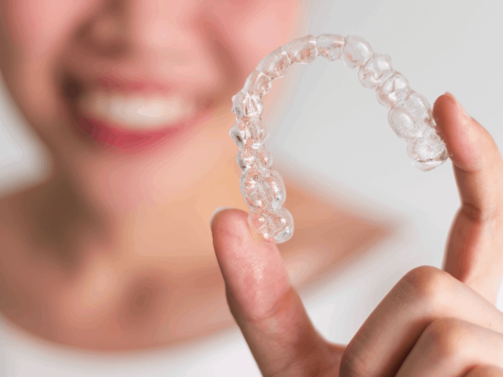 Woman holding a clear retainer between her fingers