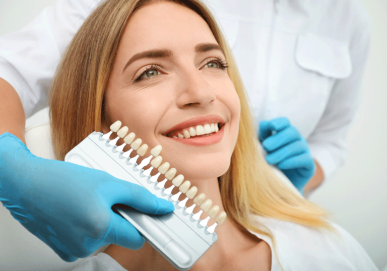 Female dental patient smiling to choose what shade she wants her teeth whitened to.